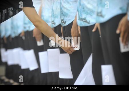 Yangzhou, Chine, province de Jiangsu. 5 Août, 2015. Les guides touristiques essayer de serrer une carte à jouer dans une formation au lac de l'Ouest mince à Yangzhou, Jiangsu Province de la Chine de l'Est, le 5 août 2015. Credit : Meng Delong/Xinhua/Alamy Live News Banque D'Images