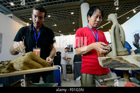 Jinan, Chine, la province de Shandong. 6e août, 2015. L'espagnol et chinois sur leur travail des sculpteurs en sculptures Convention internationale Shungeng à Jinan, province de Shandong, Chine orientale, le 6 août 2015. La troisième Culture Shanghai Expo a débuté jeudi et attire des exposants et des artistes de la maison et à l'étranger pour les œuvres d'art de la calligraphie, peinture, céramique, porcelaine, sculpture de jade rouge, la sculpture sur bois, sculpture en cuivre, de meubles anciens, le patrimoine culturel immatériel, etc. © Zhao Xiaoming/Xinhua/Alamy Live News Banque D'Images