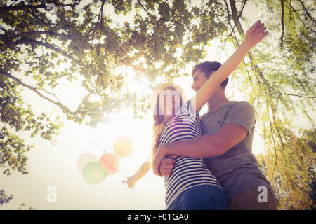 Cute couple hugging and holding balloons in the park Banque D'Images