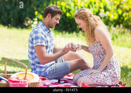 Jeune homme de mettre l'anneau au cours de proposition de mariage Banque D'Images
