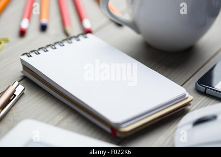 Bloc-notes sur le bureau à côté de tasse tablet et smartphone Banque D'Images