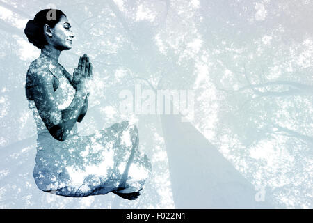 Image composite de contenu brunette en blanc assis en posture de lotus Banque D'Images