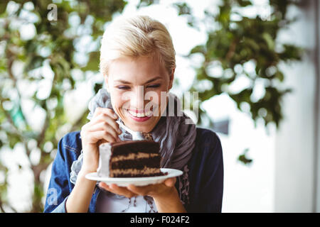 Smiling blonde en prenant un morceau de gâteau au chocolat Banque D'Images