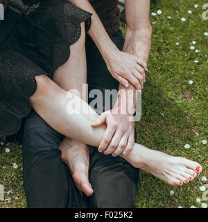 Close up of young man holding a young woman's pieds dans sa main Banque D'Images