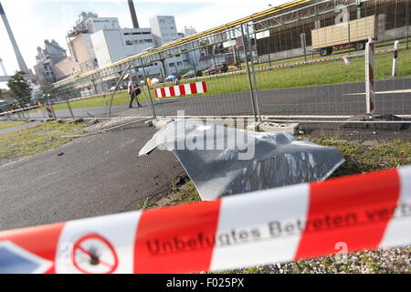 Krefeld, Allemagne. 5 Août, 2015. Un morceau de l'épave se trouve en face d'un bâtiment endommagé dans les locaux de la parc chimique à Krefeld, Allemagne, 5 août 2015. Un porte-parole de la brigade des pompiers a déclaré que 12 personnes ont été blessées, dont trois grièvement, dans une explosion qui s'est produit le mercredi 5 août. Un réservoir d'azote a explosé sur les lieux autour de 14h le mercredi à l'origine du bâtiment proche de l'effondrement. Photo : David Young/dpa/Alamy Live News Banque D'Images