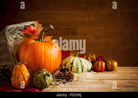 Un automne de la vie rustique encore avec des citrouilles et un panier sur une table en bois. Banque D'Images