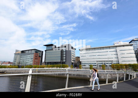 Une femme marche sur la rivière Clyde à Glasgow sur l'Broomielaw-Tradeston Bridge (connu localement sous le pont ondulées). Banque D'Images