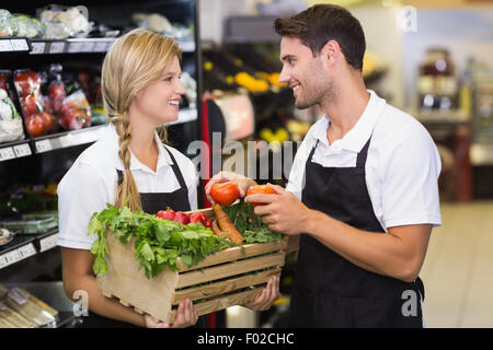 Smiling collègues tenant une boîte avec des légumes frais Banque D'Images