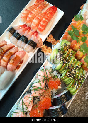 Gros plan d'un assortiment de sushis avec petits pains nigiri et maki californien Banque D'Images