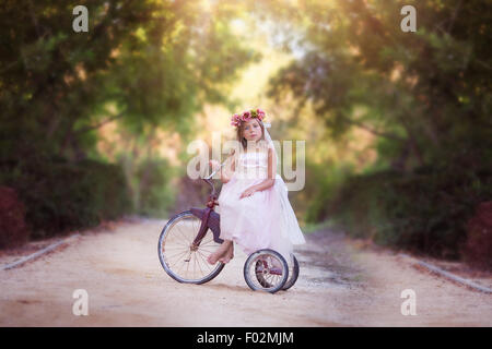 Fille assise sur un vélo d'époque sur une route de campagne, Californie, États-Unis Banque D'Images