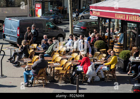 Les gens assis à l'extérieur café parisien en hiver Banque D'Images