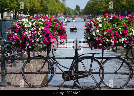 Vélo hollandais traditionnel garé sur un canal à Amsterdam Banque D'Images