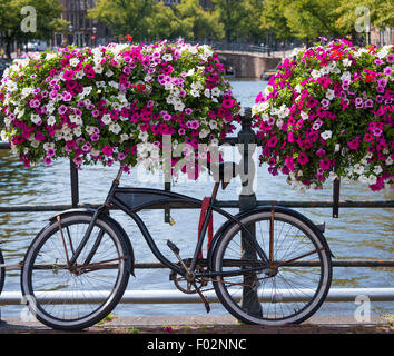 Vélo hollandais traditionnel garé sur un canal à Amsterdam Banque D'Images