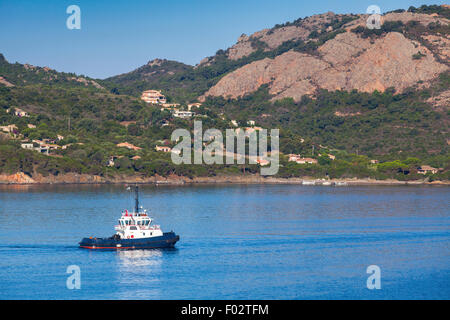 Petit bateau remorqueur avec superstructure blanc en cours sur la baie de Porto-Vecchio, Corse, France Banque D'Images