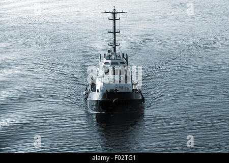 Tug boat en cours, vue avant, bleu foncé, filtre de correction tonale retro style Banque D'Images