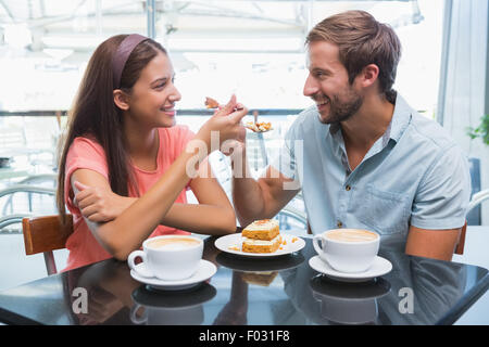 Young woman eating cake ensemble Banque D'Images