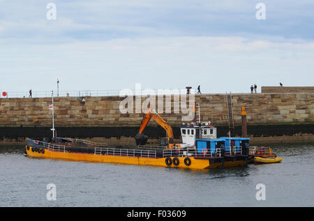 Le dragage du port de Whitby drague et le transfert de la boue dans une barge prêt à prendre la mer et sous-évaluées. Banque D'Images