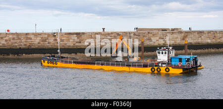 Le dragage du port de Whitby drague et le transfert de la boue dans une barge prêt à prendre la mer et sous-évaluées. Banque D'Images