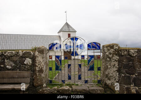 Olav's Church in Kirkjubøur sur les îles Féroé vu de la barrière avec l'art du verre dans la porte Banque D'Images