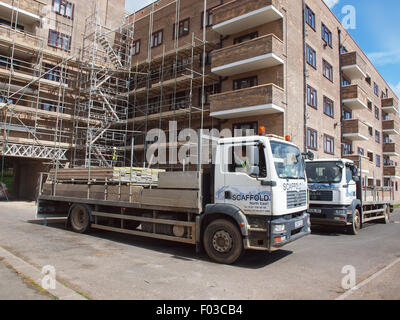 Deux échafaudages tubulaires en acier tuyau les camions qui livrent à un bâtiment pour les travaux de rénovation de ce bâtiment terminé. Banque D'Images