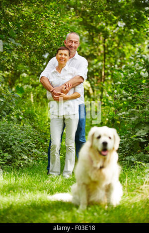 Senior couple with golden retriever dog comme animal de compagnie dans leur jardin Banque D'Images