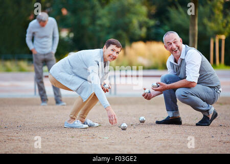 Les personnes qui jouent de la boule boules soulevant du sol Banque D'Images