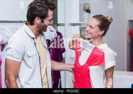 Smiling woman showing robe rouge de petit ami Banque D'Images