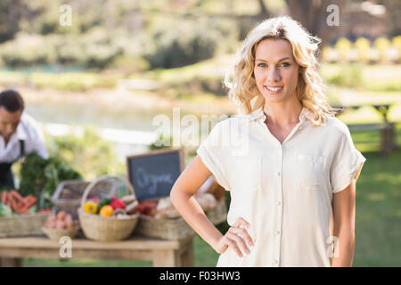 Smiling blonde woman with hands on hips Banque D'Images