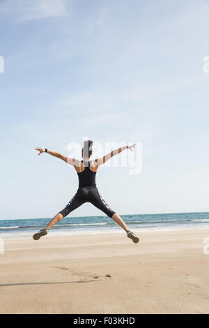 Fit woman sautant sur le sable Banque D'Images