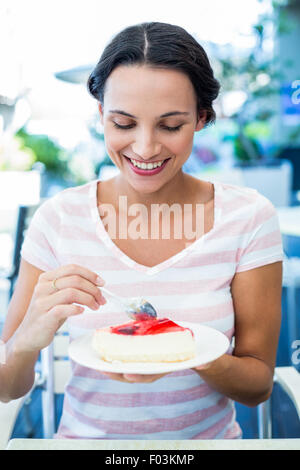 Smiling brunette en prenant un morceau de gâteau au chocolat Banque D'Images