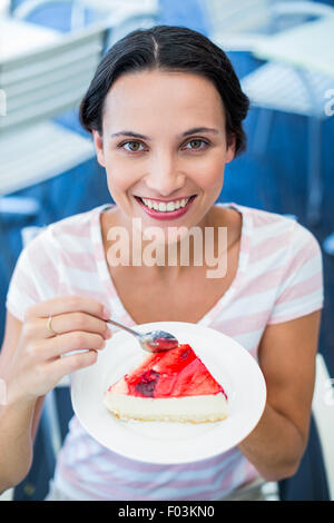 Smiling brunette en prenant un morceau de gâteau au chocolat Banque D'Images