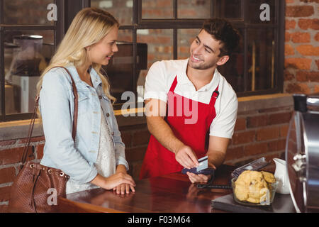 Smiling waiter glisser la carte de crédit Banque D'Images