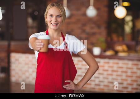 Jolie serveuse de remettre une tasse de café Banque D'Images