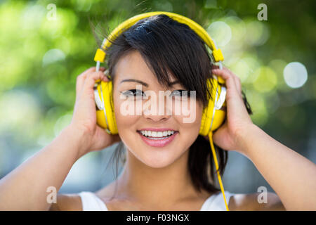 Portrait de femme portant un casque jaune athlétique et profiter de la musique Banque D'Images