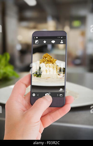 Image composite de la main tenant un smartphone Banque D'Images