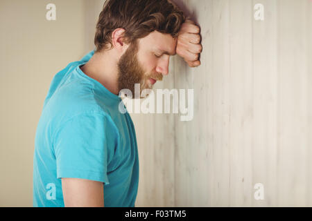 Hipster troublée leaning against wall Banque D'Images