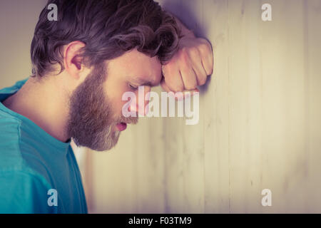 Hipster troublée leaning against wall Banque D'Images