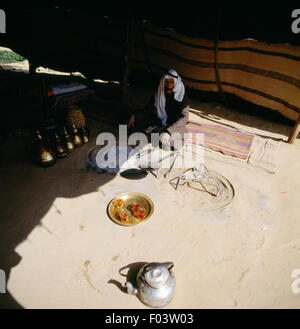 Bedouin homme assis avec du thé et des théières, dans une tente, désert de Judée en Israël. Banque D'Images