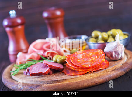 Salami, saucisses et jambon sur la planche de bois Banque D'Images