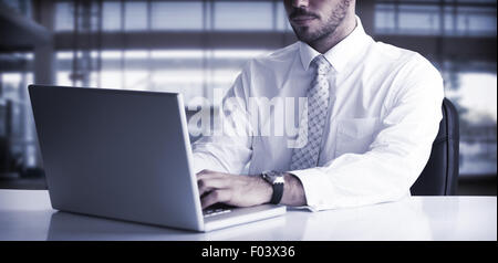 Cheerful businessman using laptop at desk Banque D'Images