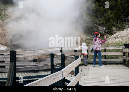 Mère avec les enfants faire de photo dans la région volcanique de boue, le Parc National de Yellowstone Banque D'Images