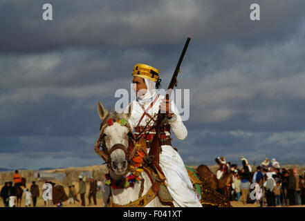 Cavalier berbère en vêtements traditionnels tenant un fusil, Festival du Sahara à Douz, Tunisie. Banque D'Images