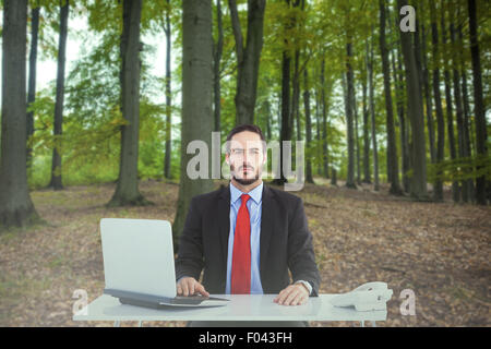 Composite image of businesswoman sitting at desk Banque D'Images