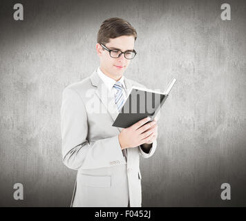 Image composite de geeky businessman reading livre noir Banque D'Images