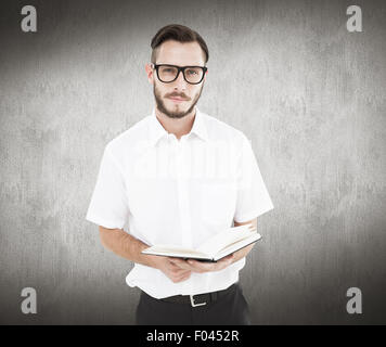 Image composite de geeky jeune homme de la lecture du livre noir Banque D'Images