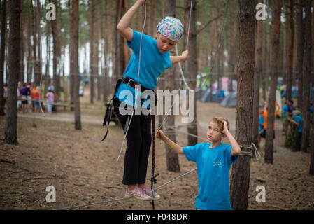 Les Scouts d'escalade sur un parcours de cordes basse en camp de formation scout ukrainien, région de Kiev, Ukraine Banque D'Images