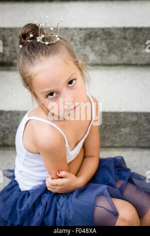 Triste / ennuyer / en colère petite princesse avec couronne d'or sur sa tête. Focus sélectif. Banque D'Images