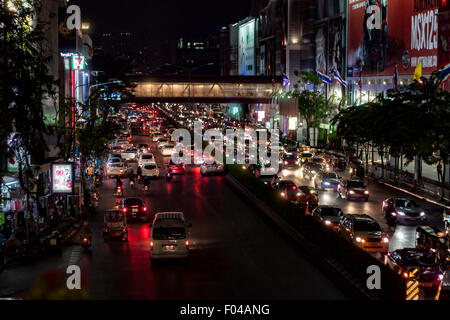 Une rue animée de Bangkok de nuit avec des longues files de voitures à l'arrêt essayant de passer à travers le trafic urbain. Banque D'Images