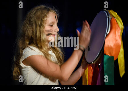 Fille jouant un tambourin dans camp de formation scout ukrainien, région de Kiev, Ukraine Banque D'Images