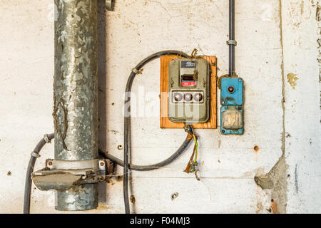 L'archéologie industrielle électrotechnique - interrupteur d'éclairage électrique vieux vieux et panneau électrique avec vannes et fusibles le long tube de métal Banque D'Images